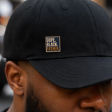 Black Father pin worn on a hat brim, showing how the Black dad lapel pin styles on a cap for everyday wear.