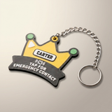 A novelty keychain shaped like a yellow and black emergency contact name tag with a silver metal chain and key ring, shown on a plain light background.